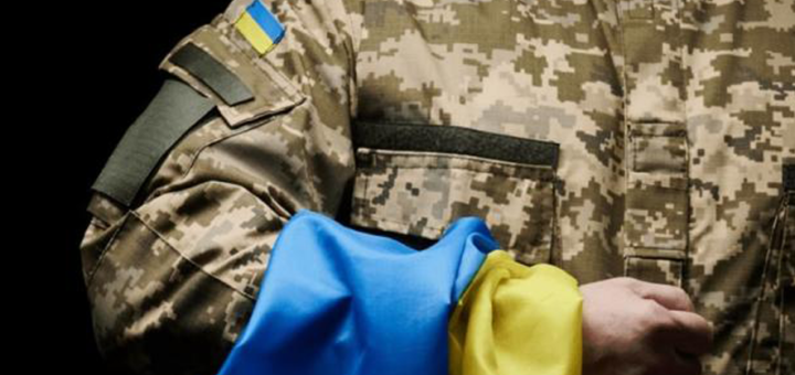 військовий тримає на руці прапор України