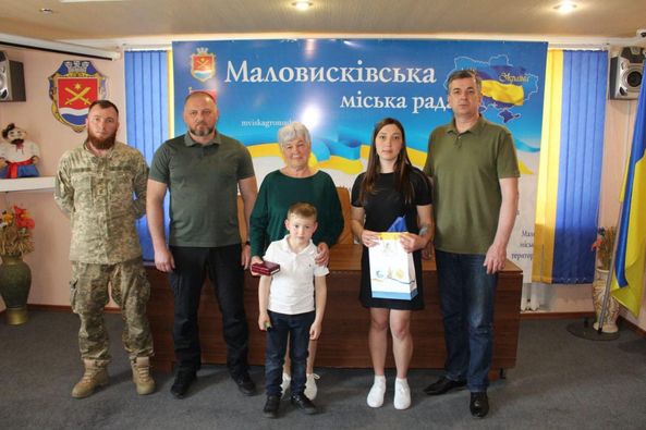 На фото родина загиблого оборонця Херсона отримує орден «За мужність» ІІІ ступеня