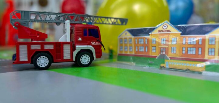 на столі іграшкова червона пожежна машинка