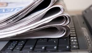 На клавіатурі лежать звернуті пачки газет