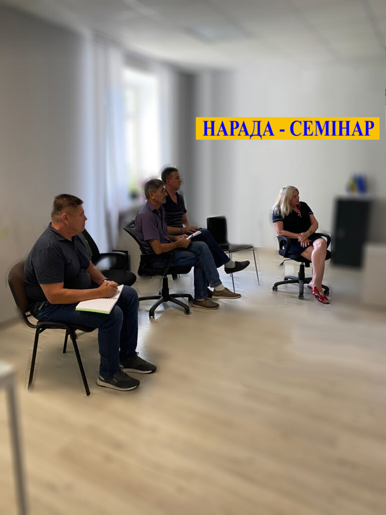Нарада-семінар: в світлому приміщені перед ноутбуком сидять 3 чоловіки та жінка  