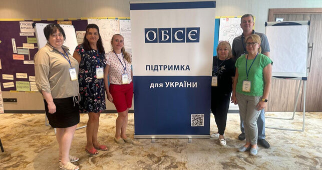 Державні службовці Херсонської районної державної (військової) адміністрації біля стенду «ОБСЄ – Підтримка для УКРАЇНИ»