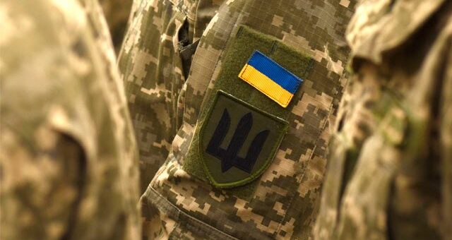 на одязі військового - нашивки: прапор України та Тризуб