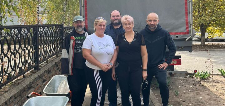 Чоловіки та жінкі стоять біля вантажівки