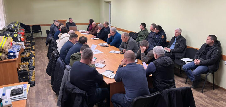 У великій світлій кімнаті за довгим столом сидять учасники наради -семінару