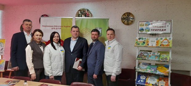 6 учасників пресконференції, присвяченої підписанню Положення про проведенню Міжнародного екологічного конкурсу дитячого малюнка «Майбутнє планети у наших руках!», біля плакату конкурсу