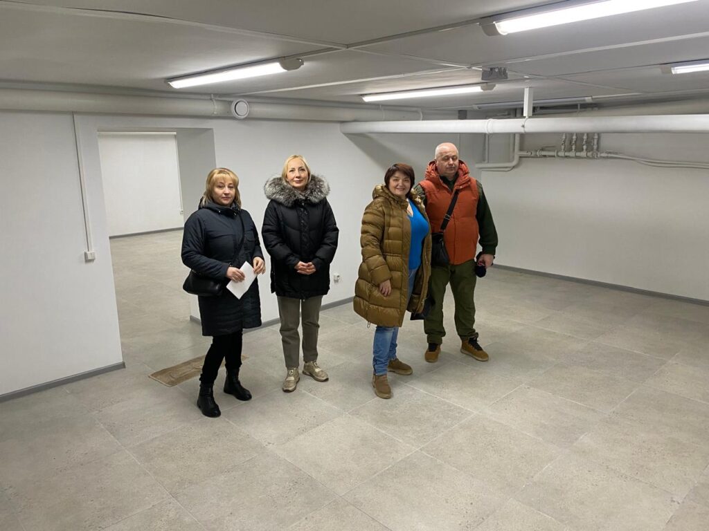 Михайло Жадан, Олена Міхєєва, Лариса Грицань та Лариса Марченко оглядають світле відремонтоване підвищення підвалу