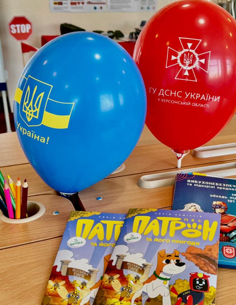 Повітряні кульки з гербами України та ДСНС поруч із дитячими книжками на столі