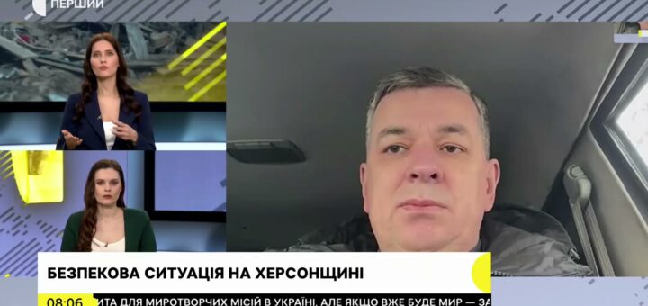 На зображенні скріншот із новинного випуску. Ліворуч видно двох ведучих новин, а праворуч — Михайло Линецький. На екрані текст українською мовою: "БЕЗПЕКОВА СИТУАЦІЯ НА ХЕРСОНЩИНІ".