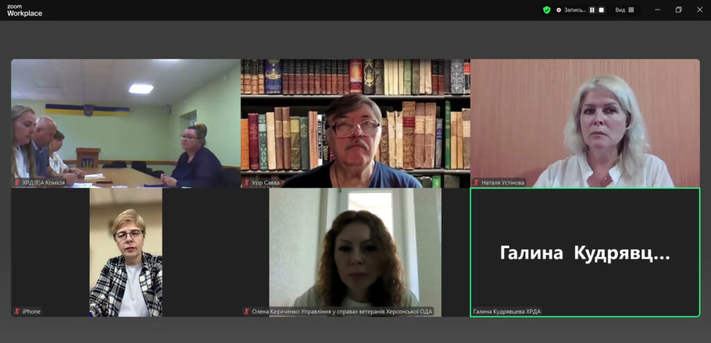 Шість учасників Zoom-конференції з різними фонами: один — на тлі українського прапора, інші — в офісі. Один учасник без відео, видно лише ім’я.