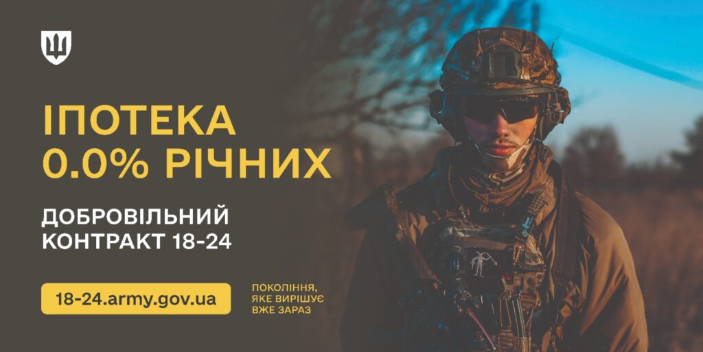На фоні природного ландшафту військовослужбовець у повному камуфляжному спорядженні стоїть із рішучим поглядом. Одяг містить каску, бронежилет і оснащення. На зображенні українською мовою розміщено мотиваційний текст: «Іпотека 0.0% річних. Добровільний контракт 18–24. 18-24.army.gov.ua. Покоління, яке вирішує вже зараз». Атмосфера патріотична та натхненна, з акцентом на молодіжне залучення й можливості, що пропонує військова служба.