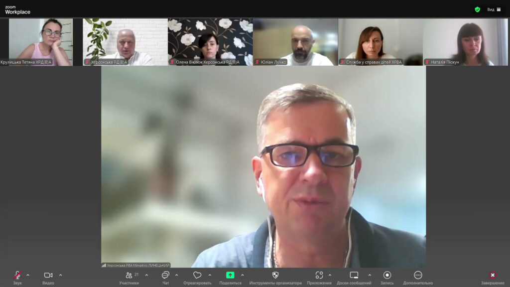 Скріншот Zoom-зустрічі з кількома учасниками. Видно відео та імена представників Херсонської РВА, служби у справах дітей та інших установ. У нижній частині — стандартна панель керування Zoom: мікрофон, відео, чат, учасники, демонстрація екрана тощо