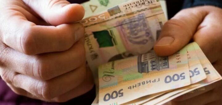 Крупний план рук, що тримають та рахують кілька банкнот номіналом 500 гривень. Усі банкноти — українські гривні