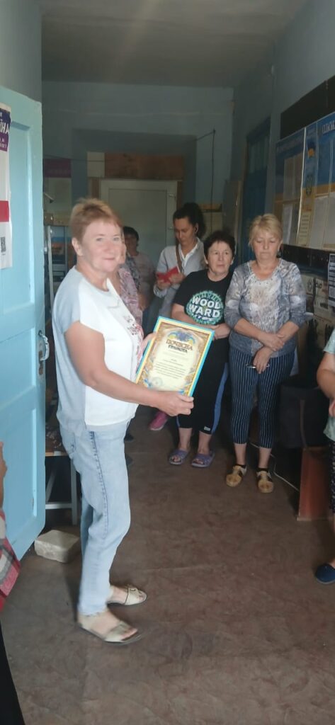 Олександр Бабуцький вручає Почесну грамоту та Подяку начальника Херсонської районної державної (військової) адміністрації  медичній працівниці зі Станіславської ТГ 