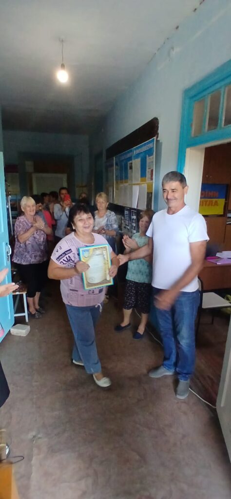 Олександр Бабуцький вручає Почесну грамоту та Подяку начальника Херсонської районної державної (військової) адміністрації  медичній працівниці зі Станіславської ТГ 