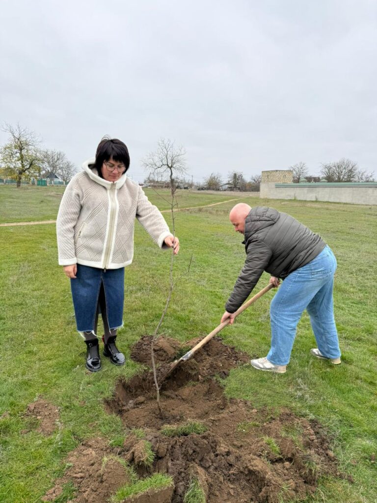 Михайло Жадан та жінка у білій куртці саджають дерево