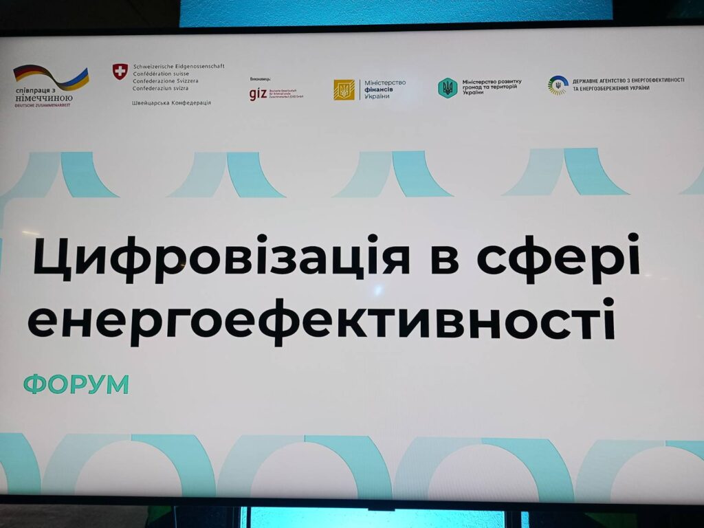 Цифровий екран із оголошенням українською: «Цифровізація в сфері енергоефективності. ФОРУМ». Угорі — логотипи організацій, зокрема Швейцарської Конфедерації, GIZ, Міністерства фінансів України, Міністерства розвитку громад і територій, Держенергоефективності.
