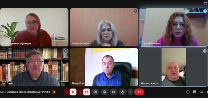 Скріншот онлайн-зустрічі з шістьма учасниками. Серед них: Кудрявцева — на фоні рослини, Наталя Устінова — біля дерев’яної панелі, Олена Кириченко — на фоні бежевої стіни з полицею, Ігор Савва — перед книжковою шафою, Віктор Колісник — в офісі з жовтим прапором, Михайло Жадан — у салоні авто. Час — 10:33, назва зустрічі — «Засідання комісії ветеранської служби».