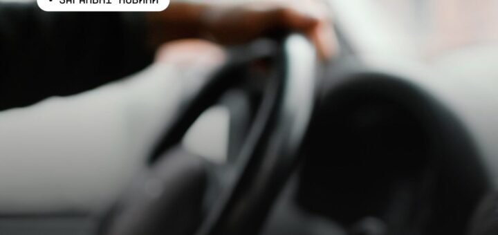 Рука людини тримає кермо автомобіля; текст українською «Загальні новини».