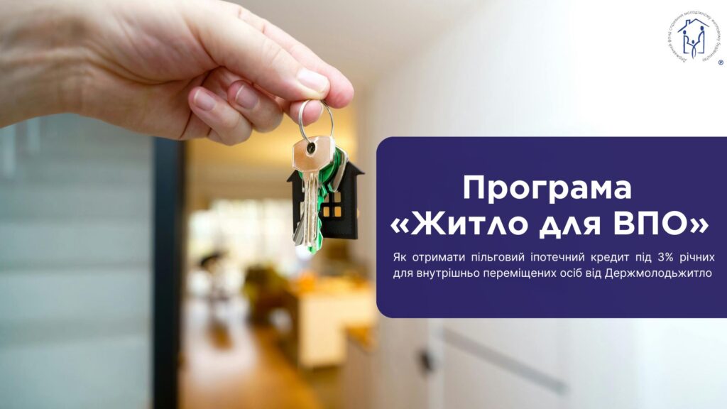 Рука тримає ключі з брелоком у формі будинку, на фоні розмитого інтер’єру та інформаційного блоку про програму житла для ВПО