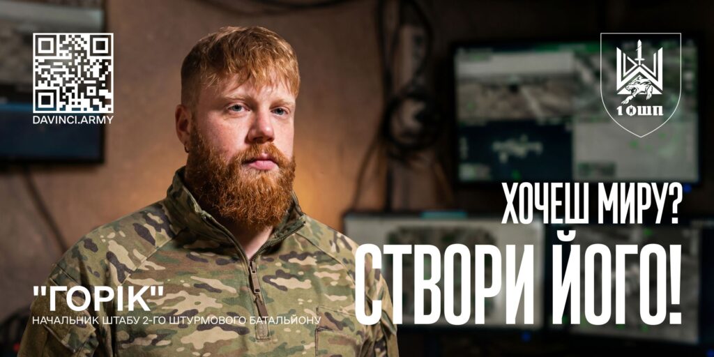 Чоловік у військовій формі з рудим волоссям та бородою стоїть у приміщенні з моніторами, текст українською: “Горік. Начальник штабу 2‑го штурмового батальйону. Хочеш миру? Створи його!”