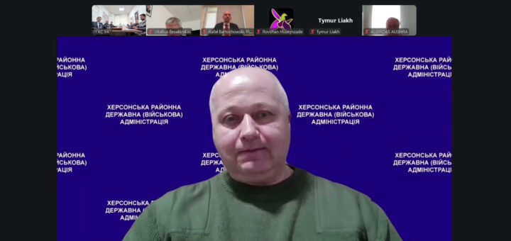 На екрані Михайло Жадан у зеленій сорочці сидить перед синім фоном із написом «Херсонська районна державна (військова) адміністрація». У верхній частині — маленькі віконця інших учасників із іменами «Vitalius Besakirskas», «Rafal Bartochowski, PL», «Rovshan Huseynzade» тощо.