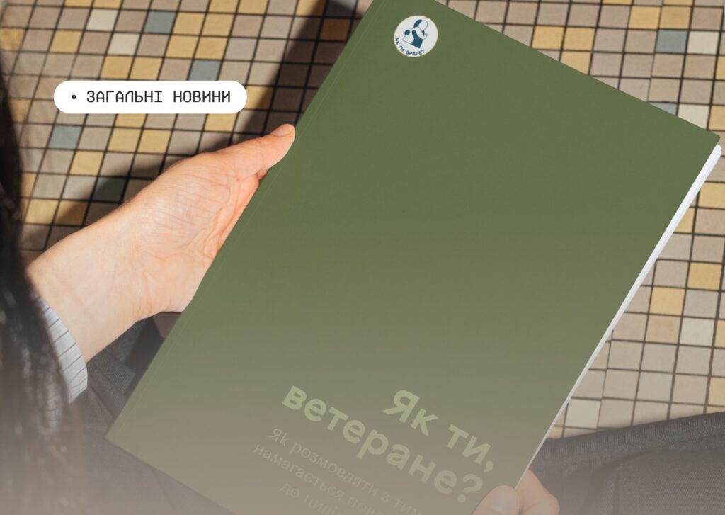 Людина тримає зелену брошуру з текстом про ветеранів, на фоні плитка з геометричним візерунком