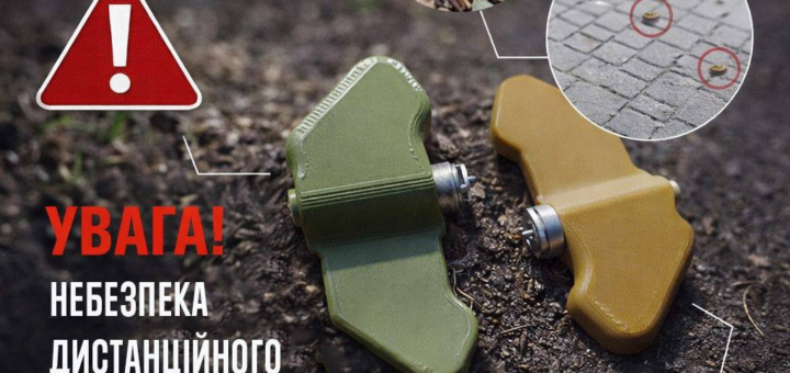 «Дві протипіхотні міни у формі метеликів лежать на землі, поруч попереджувальний знак