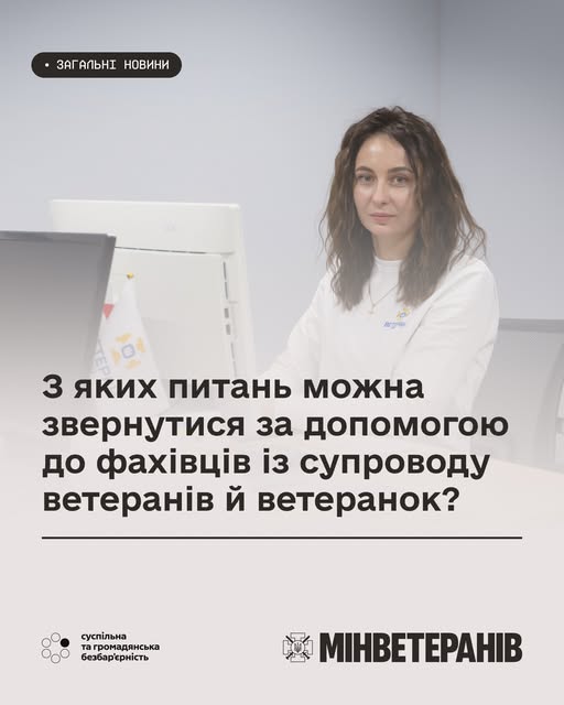 Людина сидить за столом перед комп’ютером, на екрані текст про допомогу ветеранам