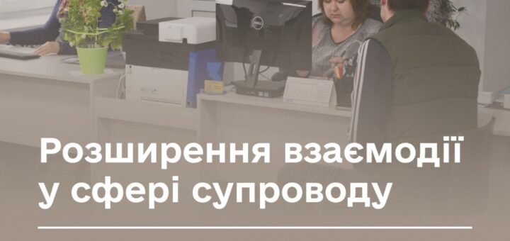 Двоє людей працюють у сучасному офісі за комп’ютерами, на екрані текст про нові можливості підтримки ветеранів