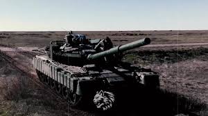 Військовий танк на ґрунтовій дорозі в полі, на броні намальована голова вовка