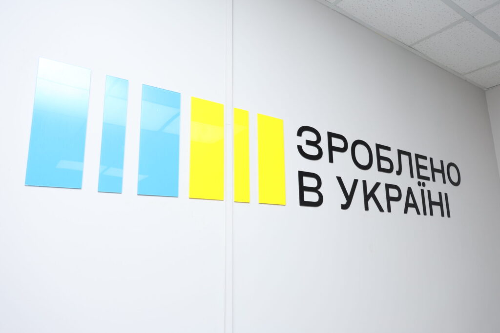 Стіна з п’ятьма вертикальними панелями — три сині та дві жовті, поряд напис “Зроблено в Україні”.