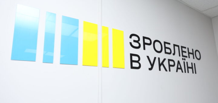 Стіна з п’ятьма вертикальними панелями — три сині та дві жовті, поряд напис “Зроблено в Україні”.