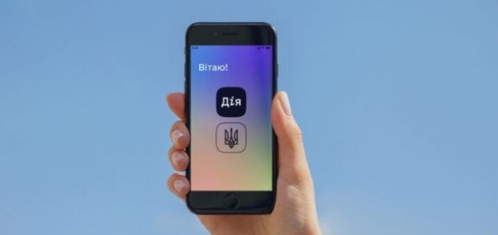 Рука тримає смартфон на тлі синього неба; на екрані іконки застосунку “Дія” та тризуб, текст “Вітаю!”.