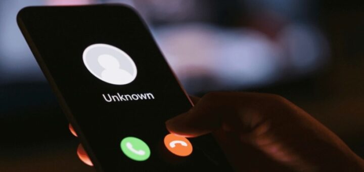 Смартфон із вхідним дзвінком від невідомого абонента, екран світиться у темряві