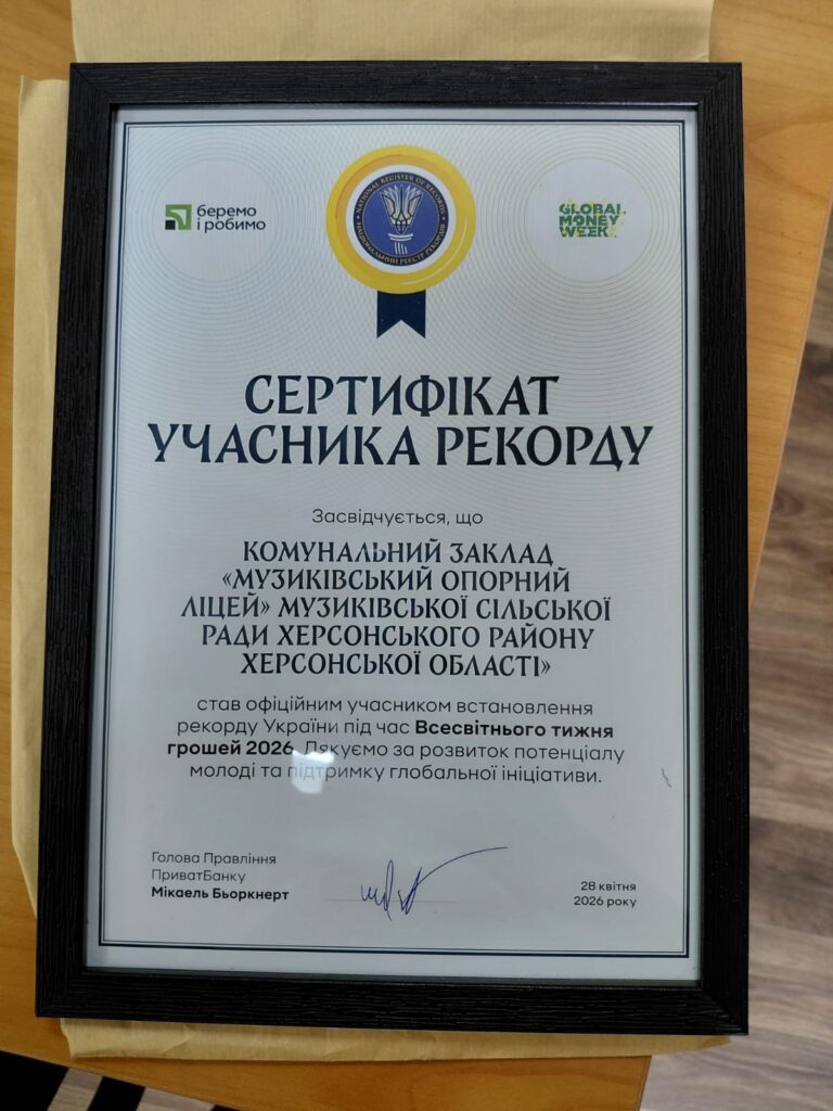 Фотографія рамки з сертифікатом. Угорі — логотипи «беремо і робимо» та «GLOBAL MONEY WEEK». У центрі — емблема синьо-жовтих кольорів. Текст підтверджує участь «Музиківського опорного ліцею» у встановленні рекорду України під час Всесвітнього тижня грошей 2026. Є підпис голови правління ПриватБанку та дата — 28 квітня 2026 року