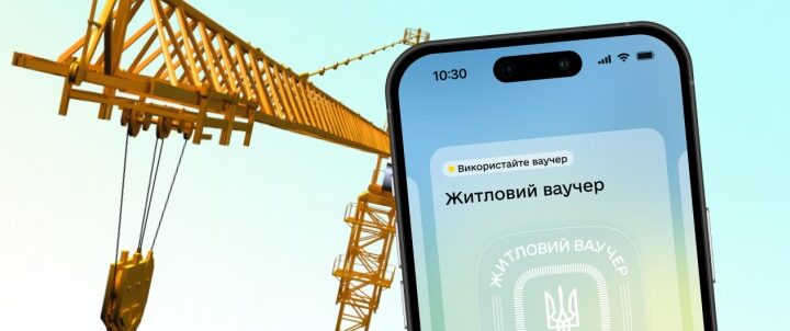 Смартфон із цифровим житловим ваучером на екрані, на тлі жовтого будівельного крану