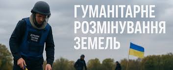 Людина у захисному спорядженні та шоломі проводить роботи з розмінування на відкритій місцевості; на тлі видно український прапор; напис українською “Гуманітарне розмінування земель”