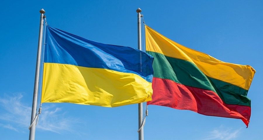 На фоні блакитного неба майорять прапори України та Литви