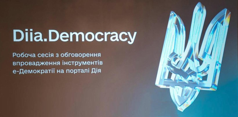 Презентаційний слайд із написом “Diia.Democracy” та блискучим скляним тризубом; тло коричнево‑синього градієнта; нижче український текст про робочу сесію щодо впровадження інструментів е‑демократії на порталі Дія