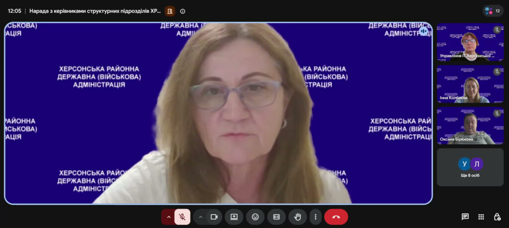 Скріншот відеоконференції. У центрі — жінка зі світлим волоссям та окулярами, позаду синій фон із написом «Херсонська районна державна (військова) адміністрація». Внизу підпис «Ілона Давидовна».