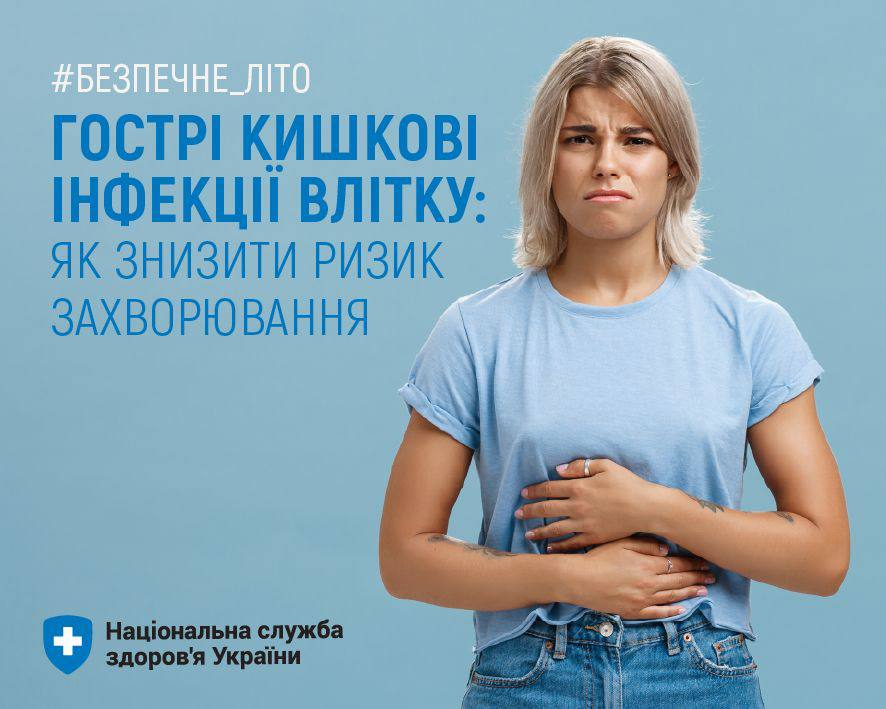 На синьому фоні стоїть людина у блакитній футболці та джинсах, тримає руками живіт. Текст українською: «#Безпечне_літо. Гострі кишкові інфекції влітку: як знизити ризик захворювання. Національна служба здоров’я України».