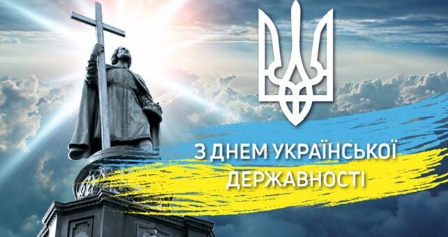 Монумент із постаттю Володимира Великого, що тримає великий хрест, на тлі драматичного неба з променями світла крізь хмари. Над пам’ятником — тризуб, український герб. Унизу — синьо-жовтий мазок із написом «З Днем Української Державності»