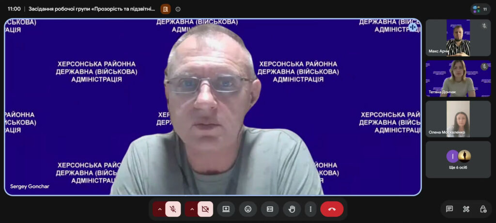 Сергій Гончар головує на засіданні. Позаду нього - синій фон, праворуч - фото інших учасників наради