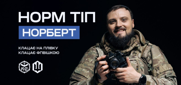 Інформаційний постер українською мовою: чоловік у камуфляжному одязі тримає фотокамеру Chinon; темний фон; ліворуч текст — “Норм тіп Норберт. Клацає на плівку. Клацає FPVшкою”; унизу два логотипи — круглий зі стилізованими елементами та інший у формі тризуба.