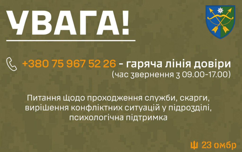 Інформаційний постер із камуфляжним фоном. Угорі великий напис: «Увага!». Далі зазначено номер гарячої лінії довіри: +380 75 967 52 26 (час звернення з 09:00 до 17:00). Текст пояснює, що лінія призначена для питань щодо проходження служби, скарг, вирішення конфліктних ситуацій у підрозділі та психологічної підтримки. У верхньому правому куті — військова емблема зі схрещеними стрілами, мечем і зіркою. Унизу праворуч — напис «23 омбр».