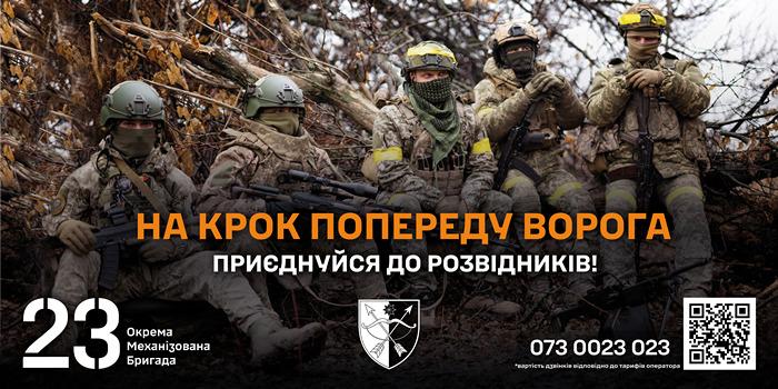 П’ятеро військових у камуфляжі та тактичному спорядженні сидять або присіли серед сухих гілок у лісистій місцевості. Усі зі зброєю, у шоломах та захисних окулярах. Текст: «На крок попереду ворога. Приєднуйся до розвідників! 23 Окрема Механізована Бригада. 073 0023 023». Праворуч — чорнобілий щит‑емблема та QR‑код. 