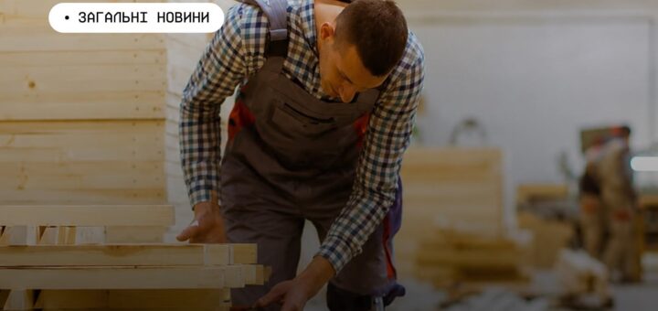 Інформаційний постер українською мовою: працівник у клітчастій сорочці та комбінезоні працює з дерев’яними дошками у майстерні; він оглядає або складає деревину; на задньому плані видно інші матеріали та ще одного працівника; угорі напис — “Загальні новини”.
