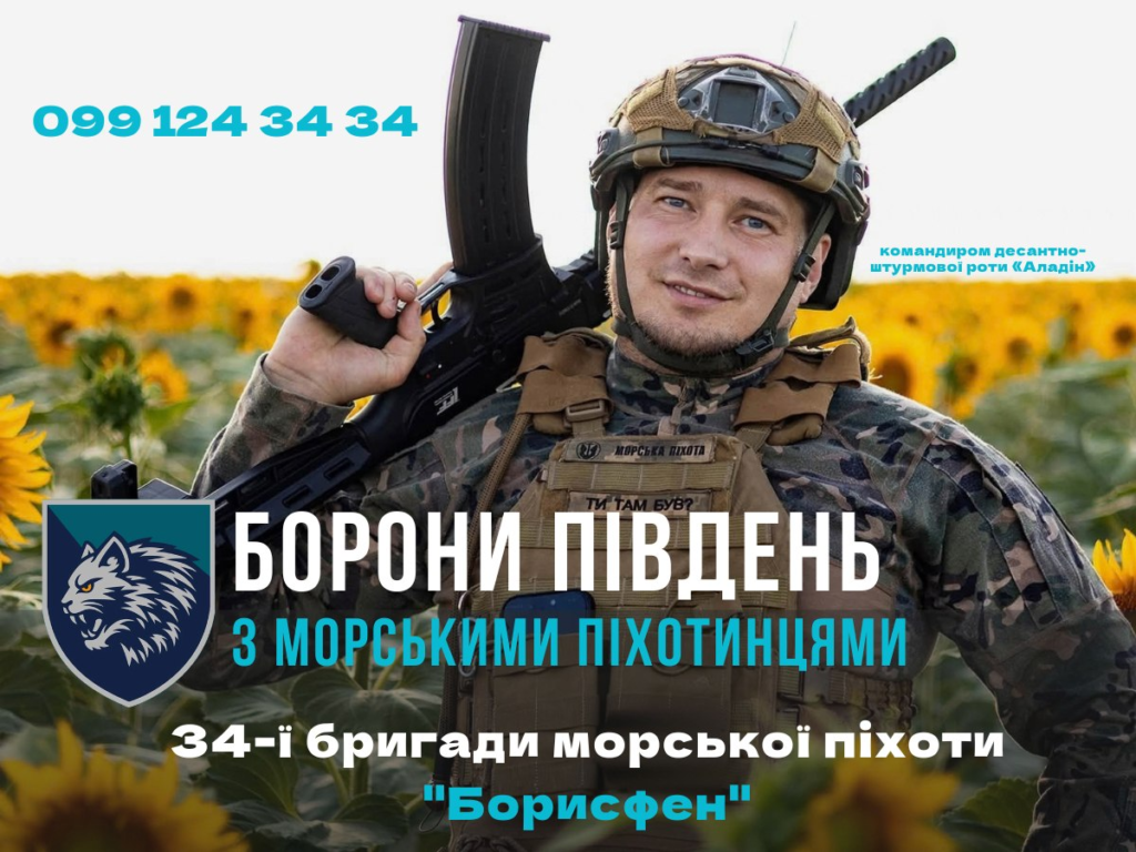 Військовий у камуфляжі та шоломі тримає автомат, стоячи серед соняшників; на жилеті нашивка “Морська піхота”; у нижньому лівому куті логотип із вовчою головою; текст українською — “099 124 34 34. Командиром десантно‑штурмової роти «Аладін». Борони Південь з морськими піхотинцями 34‑ї бригади морської піхоти «Борисфен».”