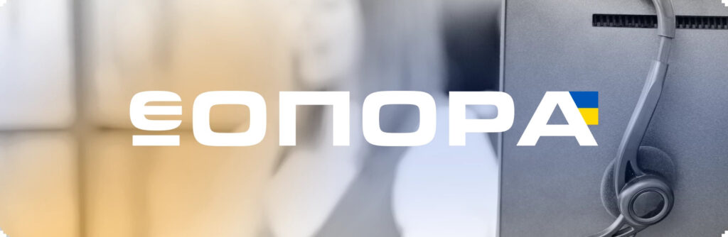 Навушники висять на моніторі комп’ютера, на зображенні білими літерами написано «ЄОПОРА», остання літера «А» має елемент українського прапора